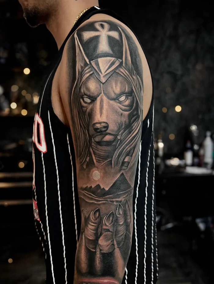 Tatuaje de Anubis, cruz egipcia y pirámides en el brazo